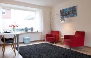恩斯赫德Shortstay Bilderdijk的客厅配有2把红色椅子和书桌
