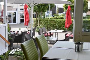 GillenfeldLandhotel Gillenfelder Hof的一个带桌椅和遮阳伞的户外庭院。
