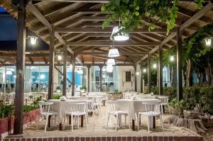 阿凯松米茂扎海滩酒店的大楼内一家带白色桌椅的餐厅