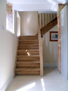 托斯特Toad Hall at Tove Valley Cottages的房屋的楼梯,有木台阶
