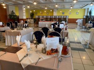 托普拉河畔弗拉诺夫Hotel Patriot的用餐室配有带白色桌布和椅子的桌子