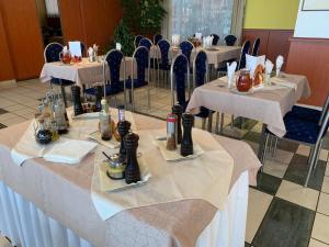 托普拉河畔弗拉诺夫Hotel Patriot的餐厅的一排桌子,有白色桌布