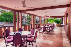 珍南海滩兰卡威我的别墅酒店的餐厅设有桌椅和窗户。