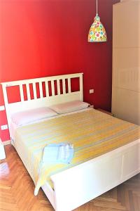 米兰米勒利尔如家公寓的卧室配有白色的床铺和红色的墙壁