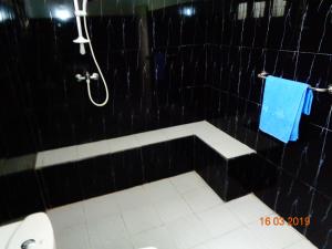 阿鲁特伽马Solal Villa的带淋浴和卫生间的黑色瓷砖浴室