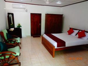 阿鲁特伽马Solal Villa的一间卧室配有一张带红色枕头的床和一把椅子