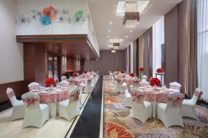 贾朗达尔Fortune Avenue, Jalandhar - Member ITC's Hotel Group的宴会厅配有桌子、白色椅子和红色鲜花