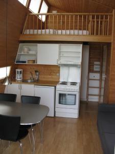 Diernæs魏凯街露营及小屋酒店的一间厨房,配有白色家电和桌椅