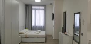 皮奥韦迪萨科Appartamento La Bottega的白色卧室配有床和镜子
