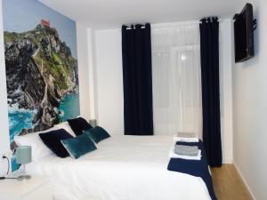 毕尔巴鄂La Concordia的卧室配有带蓝色枕头的大型白色床
