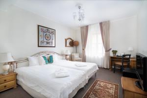 里加圣彼得精品酒店的卧室配有白色的床和电视。