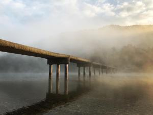 四万十市Shimanto Riverside Hideaway的雾中水体上的桥梁