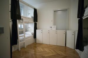 萨拉热窝The Good Place Hostel的一间设有白色橱柜和一张双层床的客房