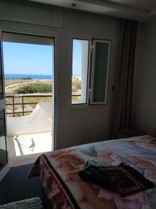丹吉尔Achakar Hills , Piscine , Vue & Accès à la mer的一间卧室设有一张床和一个美景窗户。