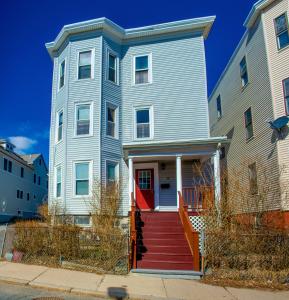 波士顿Boston Homestel的街上有一道带红色门的蓝色房子