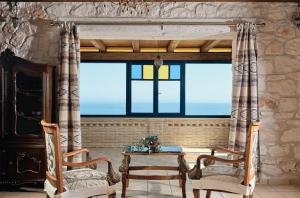 瓦西里科斯Diamond Suites的一间设有两把椅子、一张桌子和一个窗户的房间