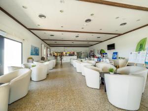 斯哥利提I Giardini di Athena- Athena Resort的等候室的一排白色椅子