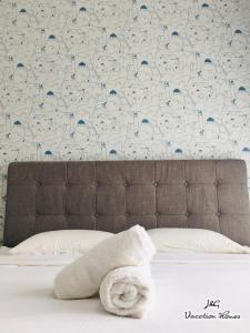 士姑来Santorini by J&G Vacation Homes的床上的毛巾,有蓝色和白色的墙壁