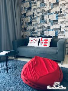士姑来City Life by J&G Vacation Homes的客厅配有蓝色长沙发及红色豆袋
