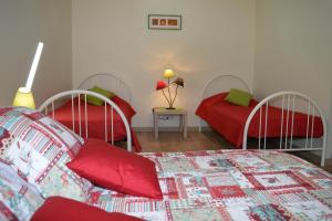 谢尔河畔阿瑟La Perronière的一间卧室配有两张带红色和绿色枕头的床