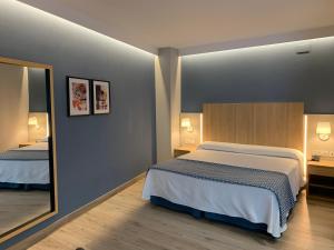 内尔哈太阳门广场酒店的一间卧室配有一张大床和镜子