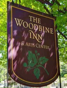 PalenvilleThe Woodbine Inn的林地旅馆和艺术中心的标志