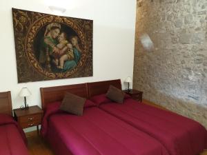 贝尔达Santuari Mare de Déu Del Mont Restaurant-Hostatgería的卧室配有红色的床,墙上挂有绘画作品