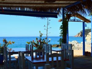 滨海托萨APPARTEMENTS SOL y MAR - Cala Llevado 2的一张桌子和椅子,背景是大海