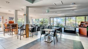 波讷地区帕朗提Vacancéole - Le Domaine des Grands Lacs的餐厅设有桌椅和窗户。