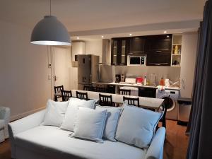 万塞讷万塞讷公寓的一间带白色沙发的客厅和一间厨房
