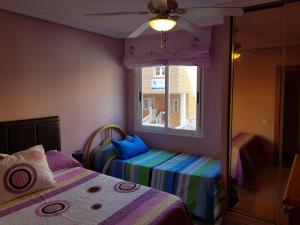 滨海罗克塔斯Apartamento Aguadulce Moreno的一间小卧室,配有两张床和窗户