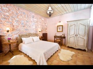 皮尔戈斯迪鲁潘多拉酒店的卧室配有白色的床和花卉墙