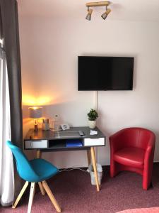 施特劳斯贝格Hotel Annablick的客房设有书桌、椅子和电视。