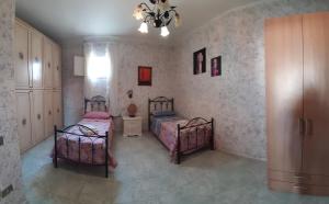 切萨雷奥港A casa di Roberto的一间卧室配有两张床和吊灯。