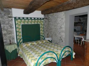 斯培西亚特拉扎苏尔贡弗乡村民宿的一间石墙内带绿色床的卧室