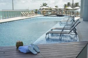 圣路易斯圣路易斯鲁泽洛斯酒店的一个带椅子和拖鞋的游泳池