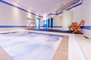 卢戈Hotel Auditorio Santiago & Spa的拥有蓝色和白色墙壁的游泳池