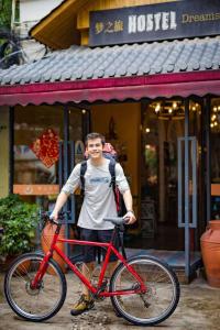 成都成都梦之旅国际青年旅舍的一座建筑前拿着一辆红色自行车的人