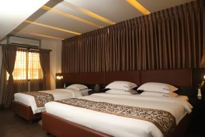 达卡Galesia Hotel & Resort的一间酒店客房,房间内设有两张床