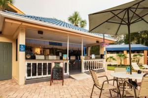 奥兰多SonoHotel IDrive Orlando的一间带桌椅和遮阳伞的餐厅