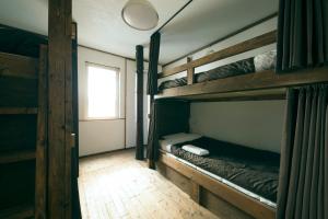 小樽Otaru Tap Room & Hostel的客房设有两张双层床和一扇窗户。