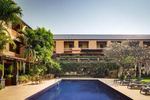 清迈Holiday Garden Hotel & Resort SHA EXTRA PLUS的一座带度假村的建筑前的游泳池
