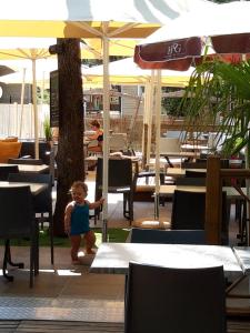 南莱潘Mobil Home Sainte Baume的站在餐厅伞下的婴儿