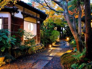 京都平八茶楼酒店的一座灯火通明的房子旁的石头路