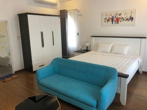 Ðưc TrọngNgoc Lan Hotel and Coffee的一间卧室配有一张床和一张蓝色的沙发