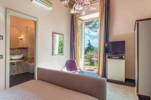 因奇萨伊恩瓦尔达尔诺黎莱斯阿尔文托别墅酒店的一间卧室设有一张床、一台电视和一个窗口。