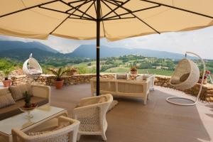 San Pietro di FelettoVilla del Poggio Prosecco Bike Hotel的一个带桌椅和遮阳伞的庭院