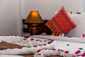 Haad Chao PhaoZama Resort Koh Phangan的两张带红白枕头和鲜花的床