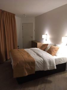 巴黎Hotel Ferney République的一间卧室配有一张大床和两盏灯