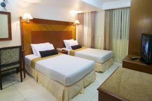 马累穆凯酒店的酒店客房设有两张床和电视。